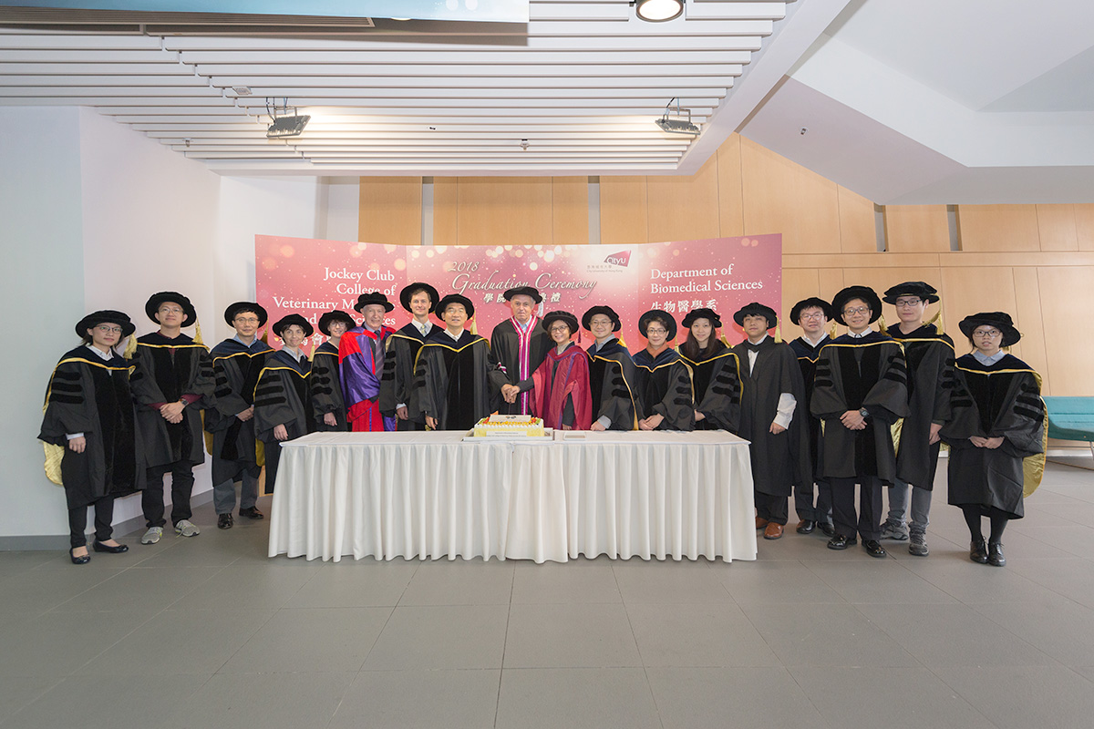 PhD graduates and Procession Members at cake-cutting ceremony.