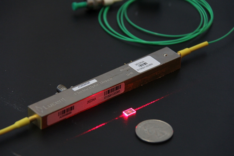 The new modulator (the red piece in centre) is much smaller than a traditional modulator and even a coin, while it drives data at higher speeds and lower costs.
