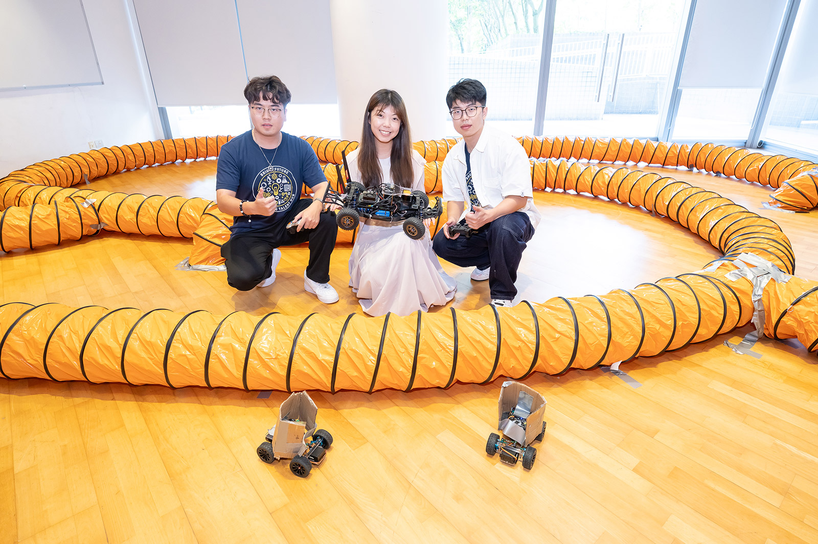 The research team demonstrates the autonomous driving racing car on a small racetrack.