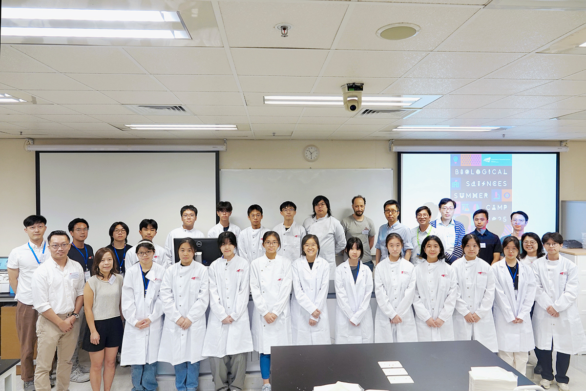 Group photo inside the BMS lab with participants in lab coats, alongside  faculty members and technical staff.