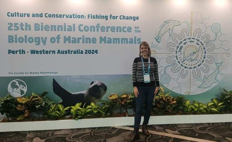 A person standing in front of a sign
Description automatically generated