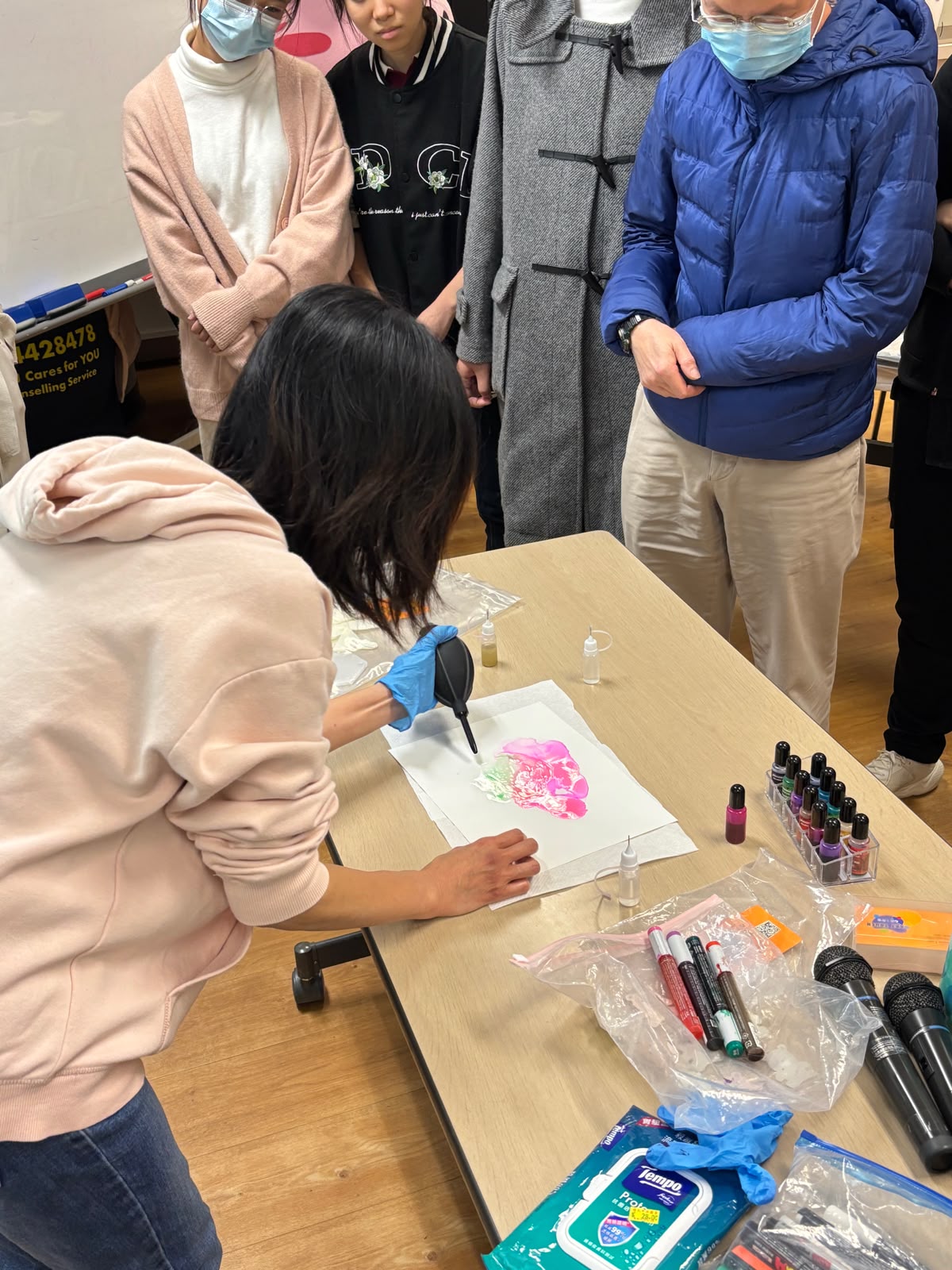 The instructor was teaching how to create alcohol ink paintings.