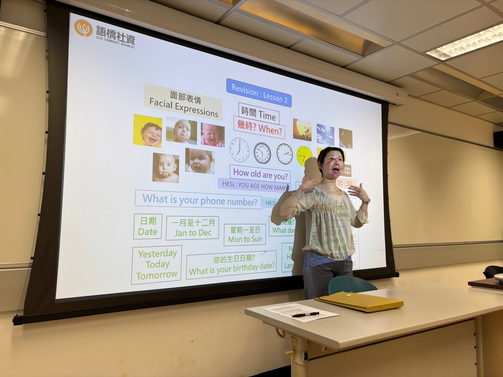 The deaf teacher was teaching sign language for facial expressions.