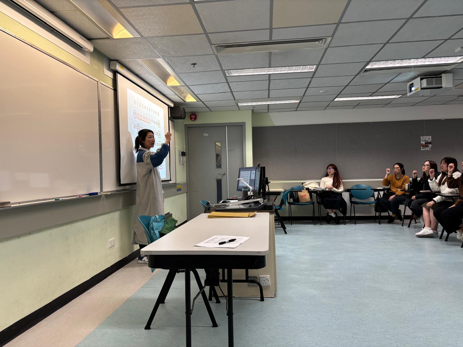 The deaf instructor was demonstrating the sign language for numbers.