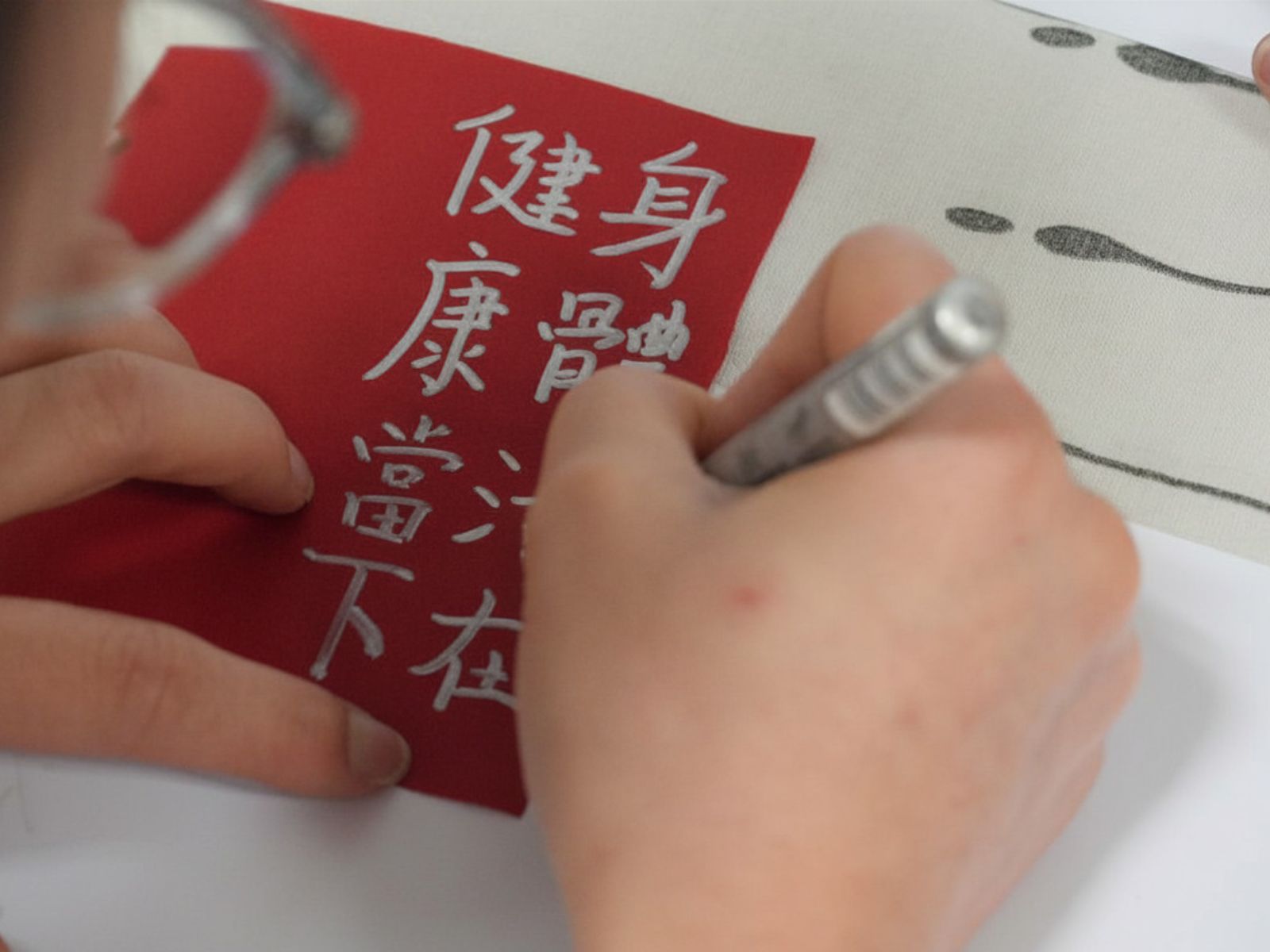 The participant was writing the blessing on the flower plaque. 參與者正在花牌上寫下祝福語。