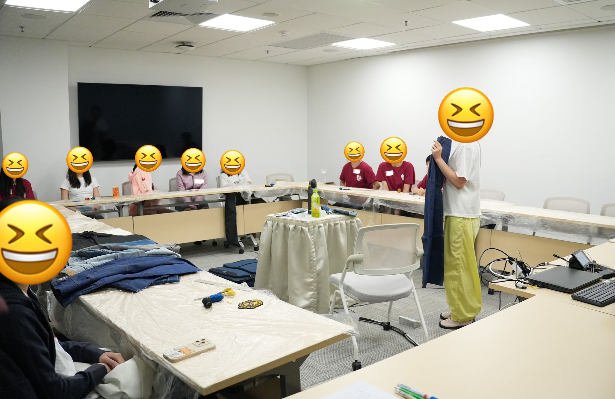 The whole class was paying attention to the introduction from the instructor on how to cut out a piece from the denim jeans.