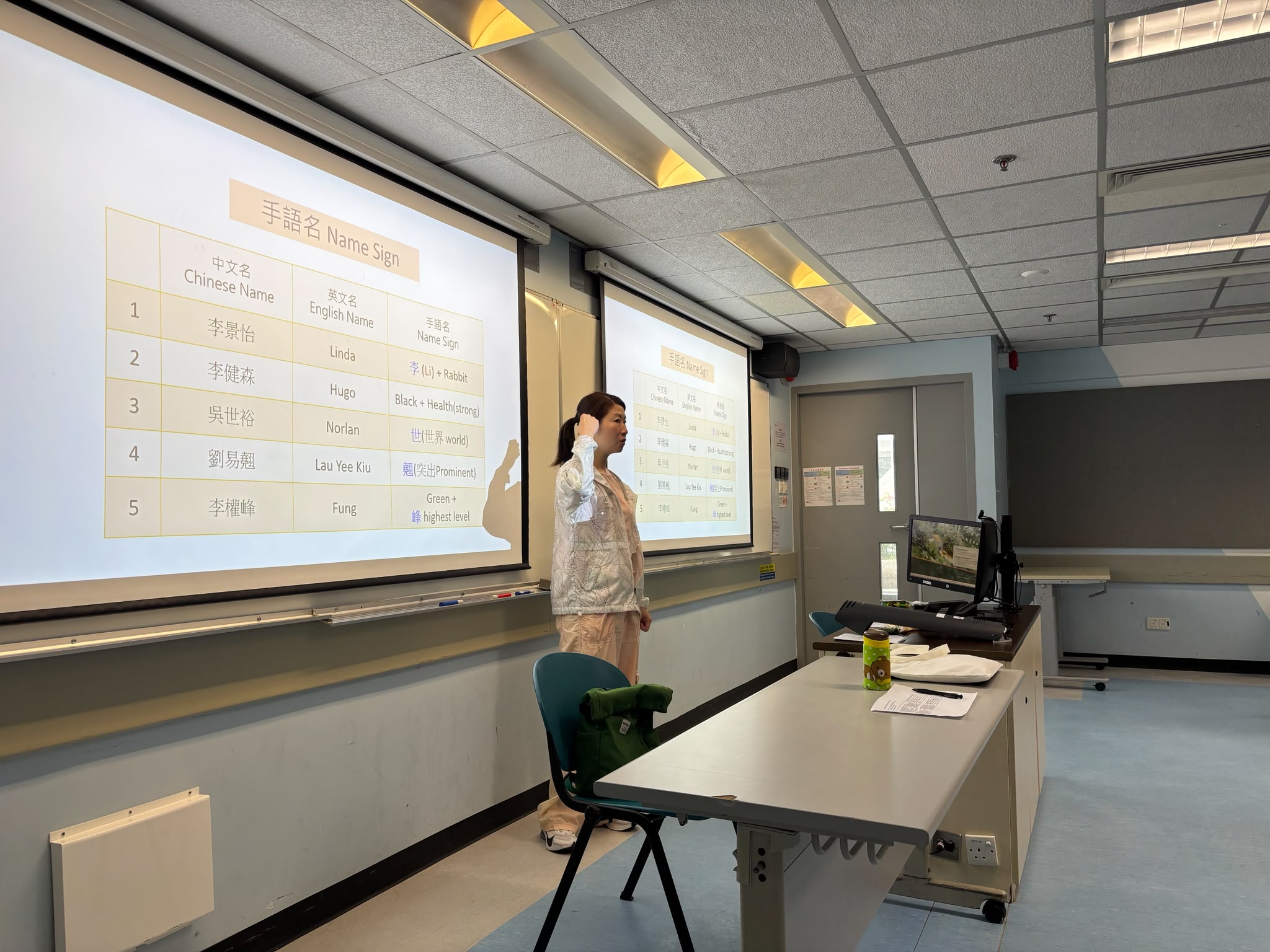 The deaf instructor was demonstrating the students' sign names.