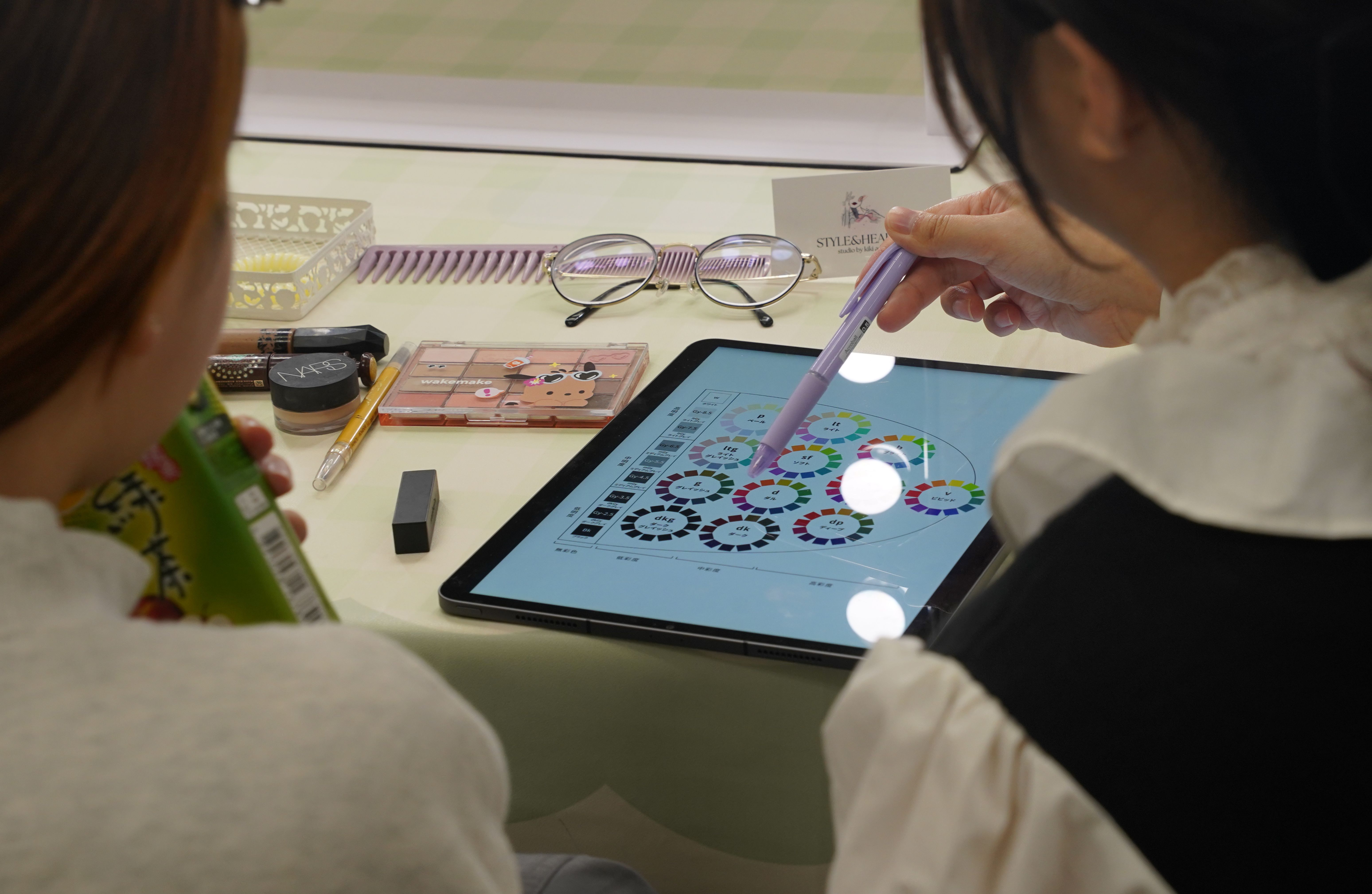 The personal color consultant is teaching students how to study the Practical Color Coordination System (PCCS). 個人色彩顧問正在教導學生如何學習《實用色彩協調系統》（PCCS）。