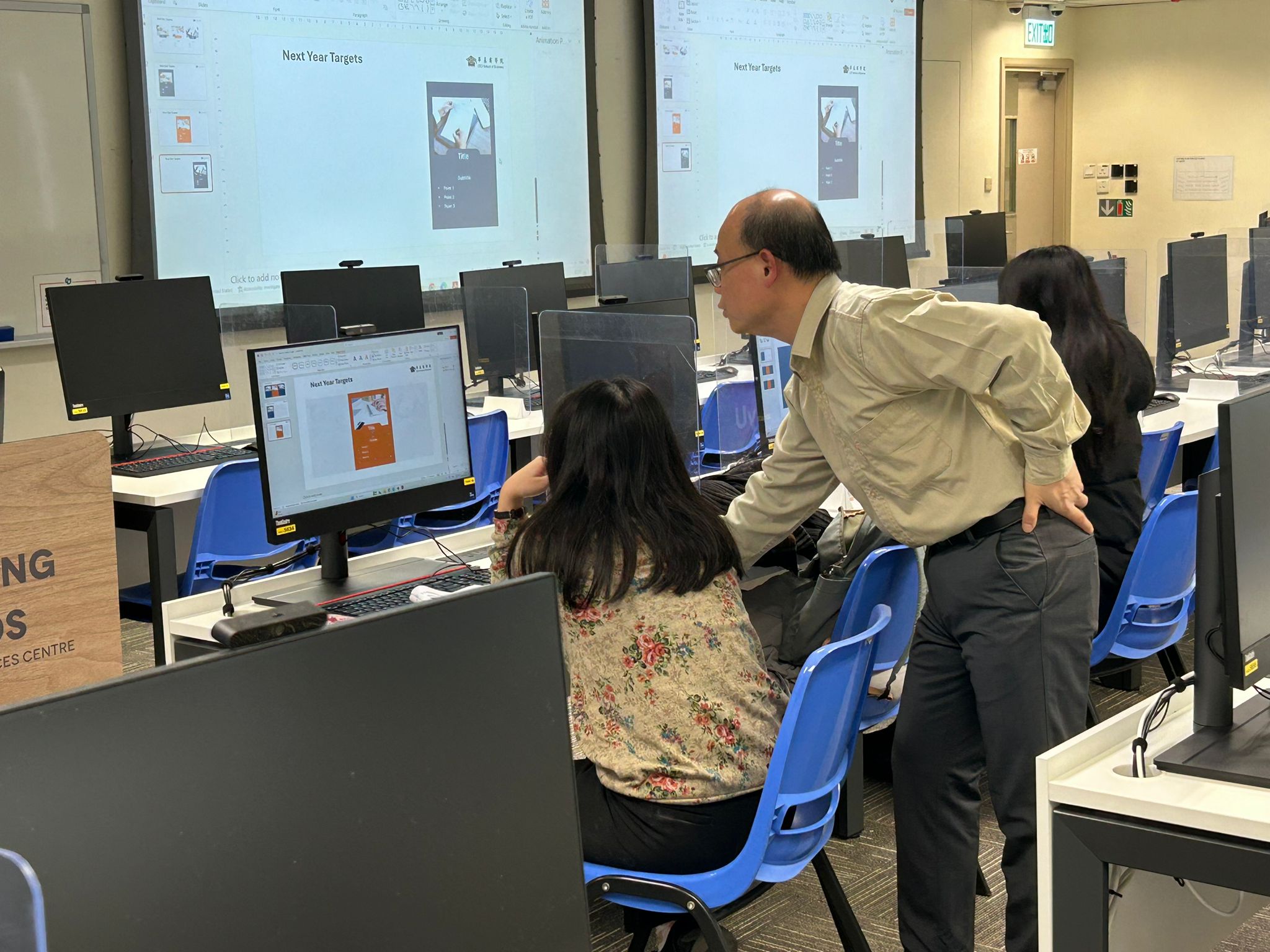 The trainer was teaching students with the Powerpoint slide transition effects.導師正在向學生解釋 PowerPoint 投影片切換效果。