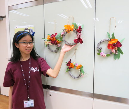 A photo of a student and her flower wreath. 同學的花環