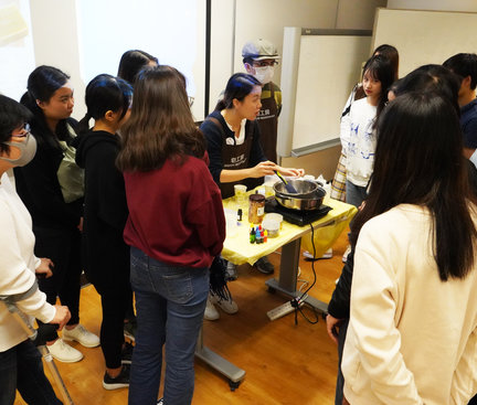 Participants were standing to surround the instructor to see the demonstration of how to make a crystal soap. 參加者站在導師旁觀學習如何製作水晶皂