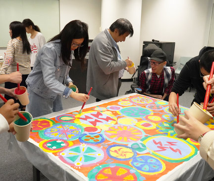 Participants painted on two rectangular paper on tables with many circular patterns and colours collaboratively. Some of the original paintings were being added with others’ paintings. 參加者用顏色塗上2張長方形的紙上。部分原有的設計再加上一些其他人的創作。