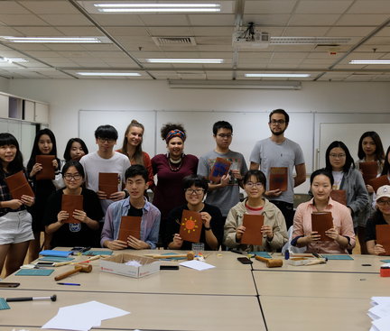 A group photo of the participants and the instructor together with their products of journal books. 參加者和導師拿着記事簿的大合照