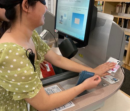 The student was borrowing books using a machine under blind conditions 同學體驗在失明的情況下使用機器借書