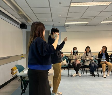 The sign language instructor invited a staff member to come forward and demonstrate her own sign name.