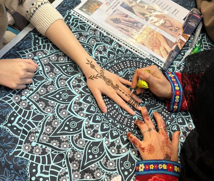 The artist was drawing Henna designs on the student's hand. 導師在學生手上繪畫Henna圖案。