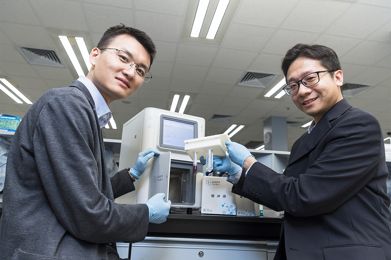 (From left) Dr Henry Zou Heng and Dr Edwin Yu Wai-kin of Cellomics, PhD graduates supervised by Professor Michael Yang Mengsu. 