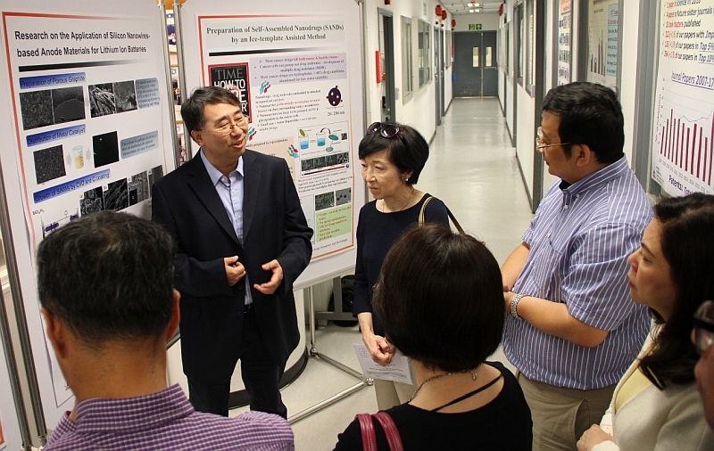 Professor Lee Chun Sing (left), Director of Centre of Super-Diamond and Advanced Films (COSDAF) and Professor Zhang Wenjun (second from right), Deputy Director of COSDAF, explain their centre’s latest research findings, such as perovskite solar cell, and applying nano-technology to improve cancer treatment.