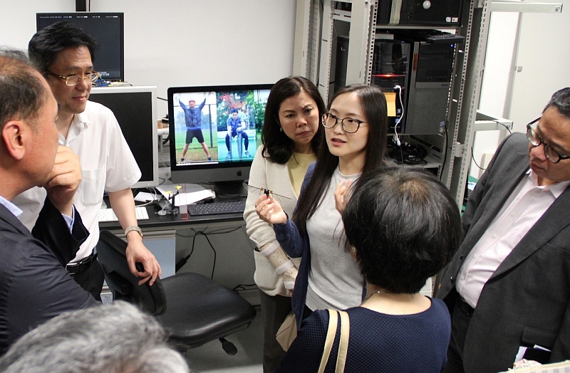 Professor Dong Sun (second from left), Director of Centre for Robotics and Automation, and his research team explain the flying robot and other research projects to the HKSTP delegation.
