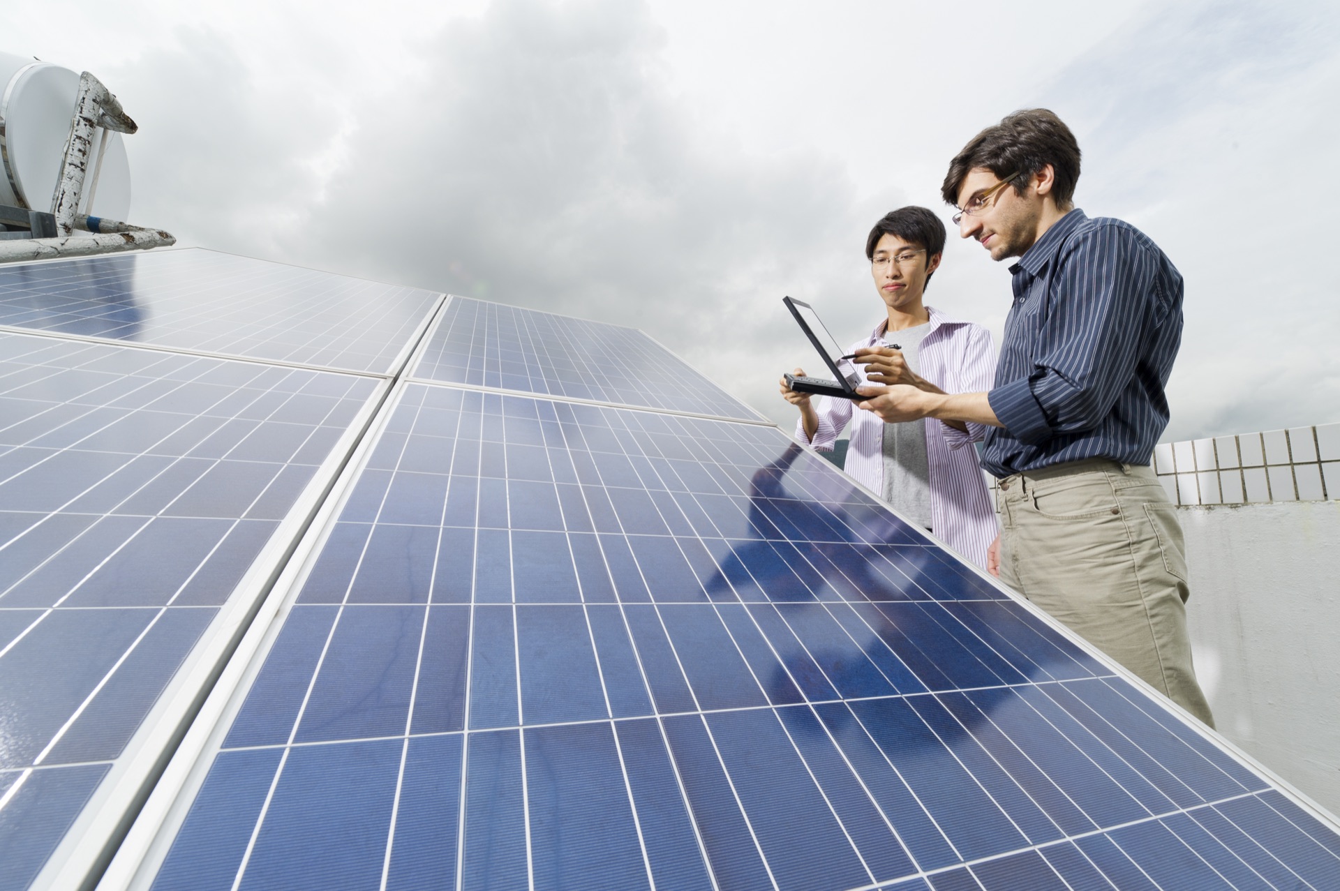 CityUHK researchers inspecting rooftop solar photovoltaic panels