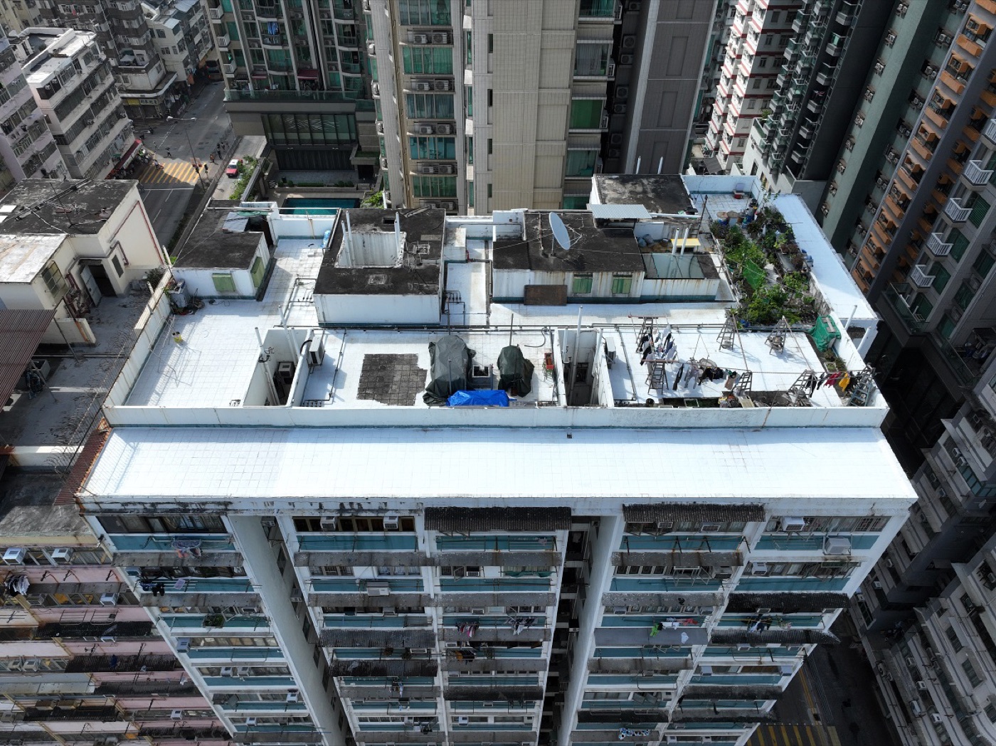 A dense Hong Kong rooftop coated in i2Cool reflective white paint, seen from above among tower blocks.