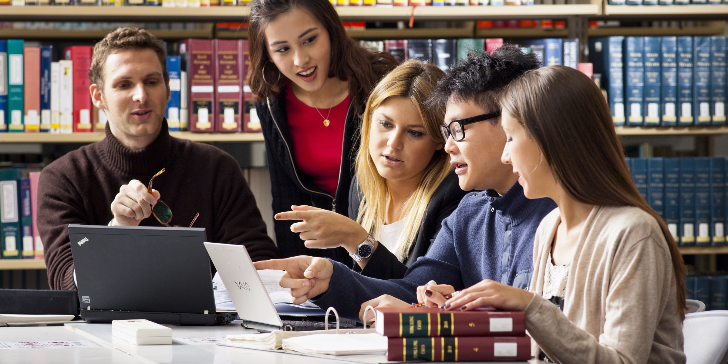 CityUHK students studying together over laptops and books in the University library