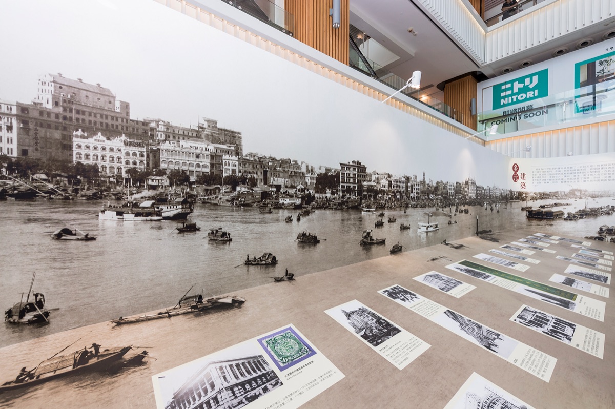 A panoramic historical photograph of the Guangzhou Bund waterfront covering the exhibition wall, with captioned archive prints displayed alongside it