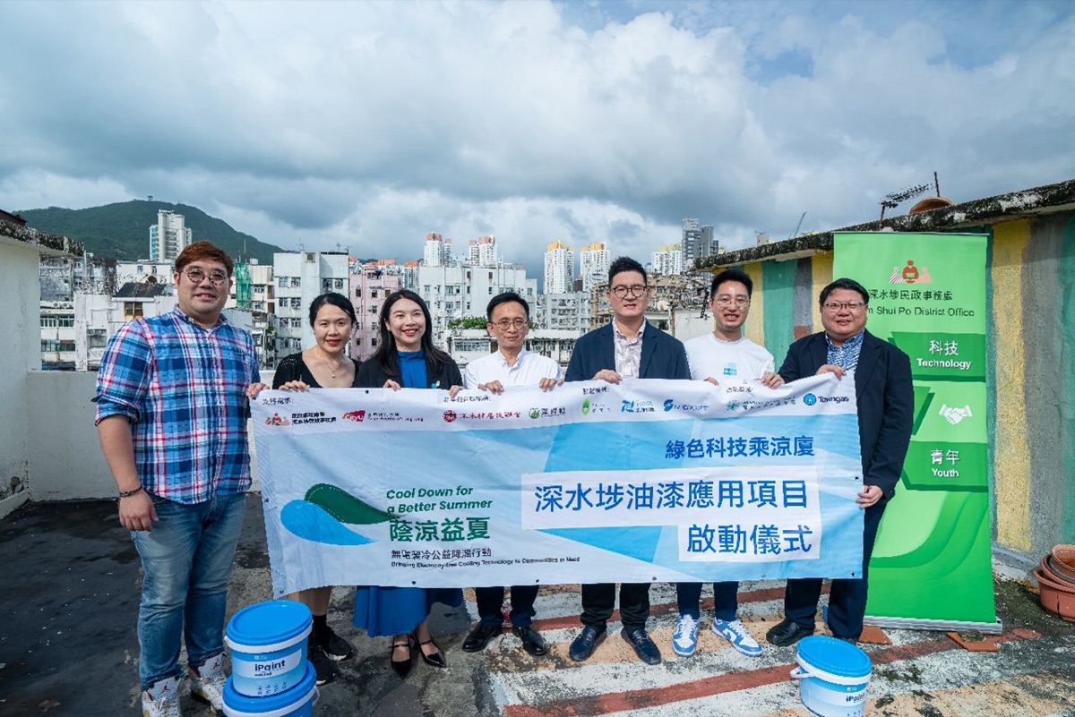 Partners from CityUHK, i2Cool and the Sham Shui Po District Office holding a "Cool Down for a Better Summer" banner on a tenement rooftop, with tubs of iPaint beside them