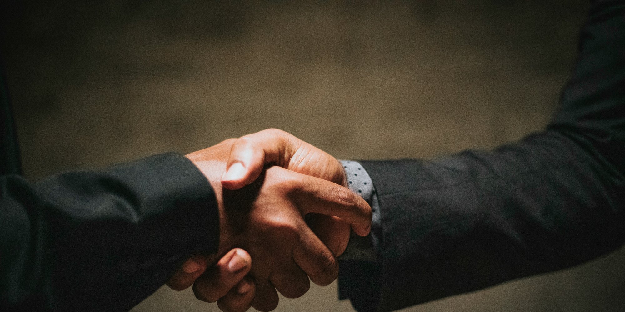 Two people in suits shaking hands